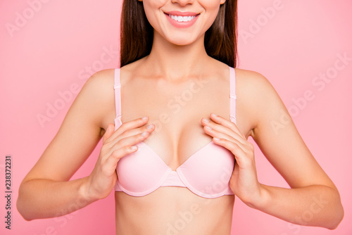 Cropped close up portrait of cute gentle gorgeous her she girl showing great result of cleavage raise in special pushup bra isolated on pink background