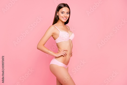 Half turned side view photo of attractive beautiful cheerful brunette her she feminine lady posing for bikini commercial promo hands by sides wearing pale pink underwear isolated on rose background