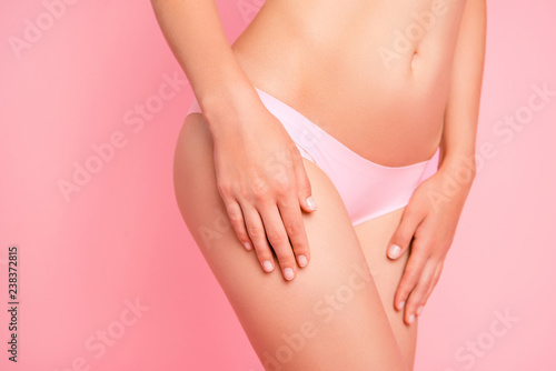 Cropped close up photo of nice attractive silky without hair and fat legs and stomach she her woman touching it with hands in pants isolated on rose background © deagreez