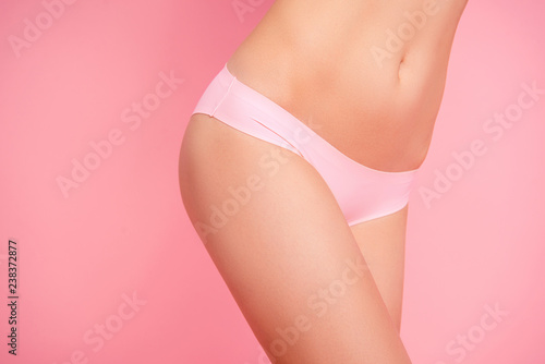 Cropped close up photo of nice beautiful attractive silky smeared fit with unti cellulite cream legs abdomen she her woman in pants isolated on rose background