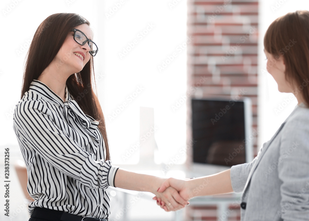 two business women shaking hands.