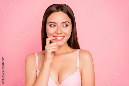 Close-up portrait of nice cute lovely sweet adorable attractive winsome feminine girlish cheerful girl in beige bra biting nail isolated over pink pastel background