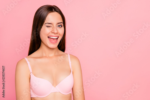 Close-up portrait of her she nice lovely lovable attractive charming cheerful positive girl in beige bra winking smooth soft healthy skin copy empty blank space isolated over pink pastel background