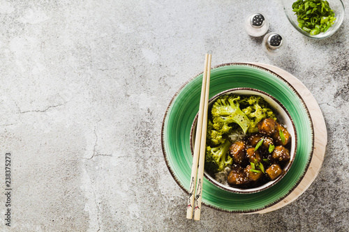 Basmati rice with tofu in General Tso sauce and steamed broccoli. full healthy vegetarian lunch or dinner on a stone table photo