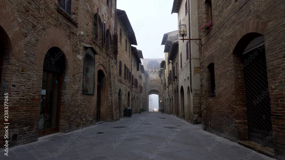 San Gimignano, Italy. Walking a narrow street of the Medieval town, filled with the aura of old times. There are old brick-walled buildings on both sides of the street. 4K San Gimignano, Italy. Walking a narrow street of the Medieval town, filled with the aura of old times. There are old brick-walled buildings on both sides of the street. 4K