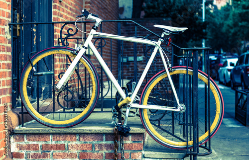 Custom mountain bicycle locked outside house metal railing, cross processed effect vintage style colour