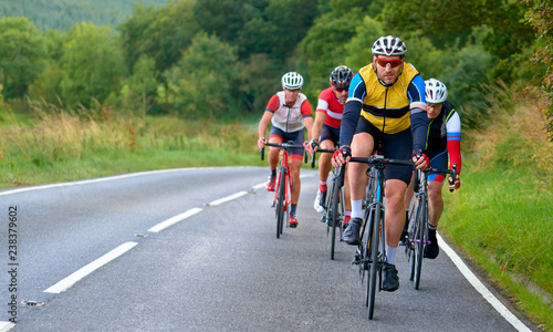 A group of cyclists on a bike race on a country roads in the UK.