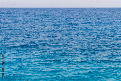 Blue sea background. Beautiful sky and blue ocean or sea. Blue sea surface with waves