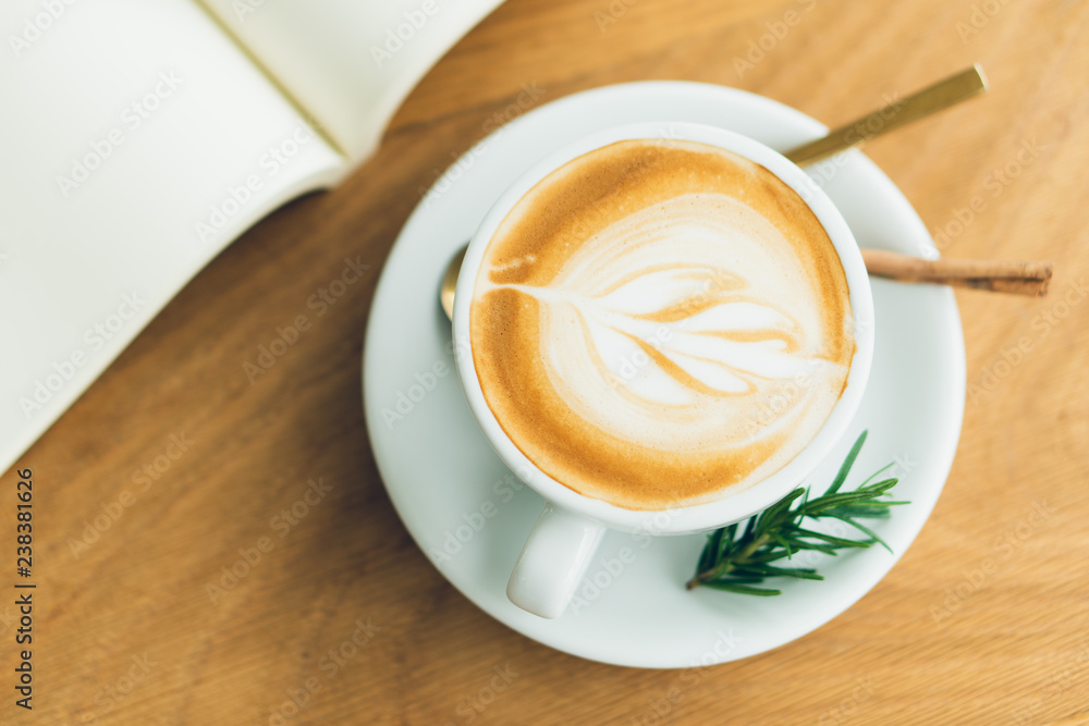 white coffee mug. Coffee is a latte. table on the wooden table in vintage style, taken from the top view, see the froth of milk foam. white coffee mug. Coffee is a latte. table on the wooden table in vintage style, taken from the top view, see the froth of milk foam.