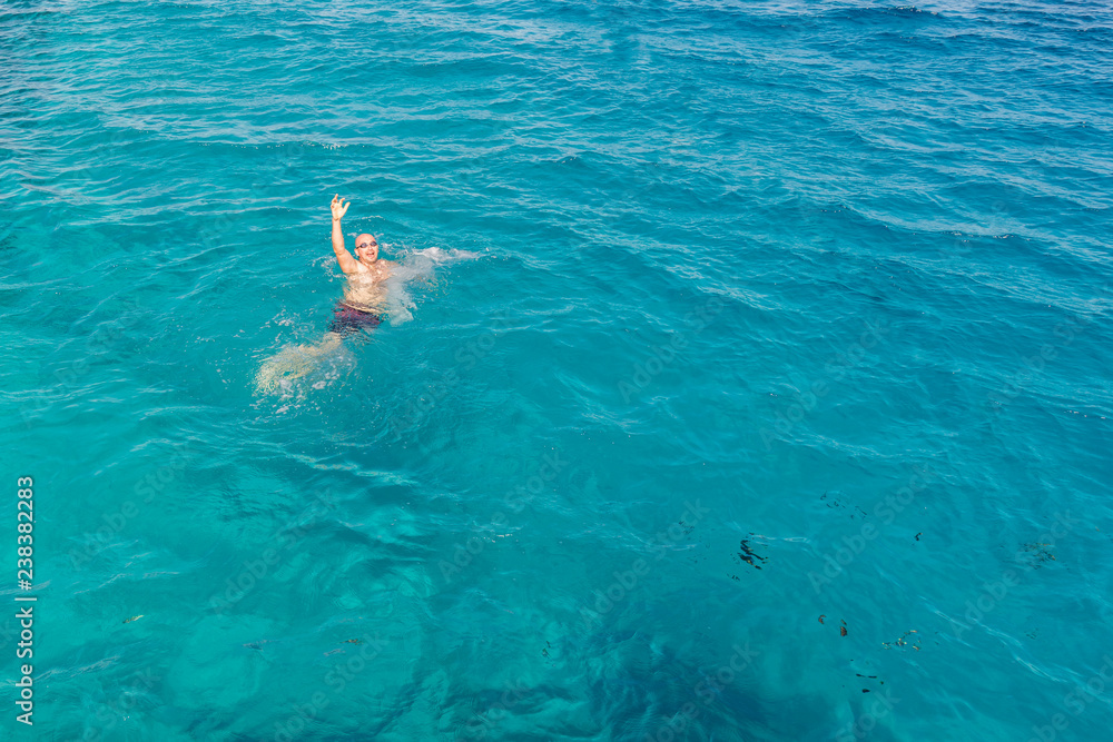 Drowning man in sea asking for help with raised arms. The man is drowning in the sea. man drowning in the sea and waving hand for help