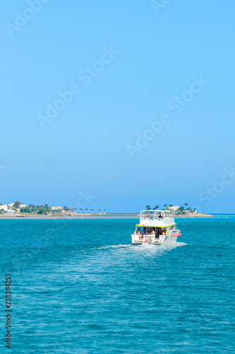 The boat goes on the open sea. aerial view of cruise tourist travel boat going on the sea. vertical photo. © jollier_
