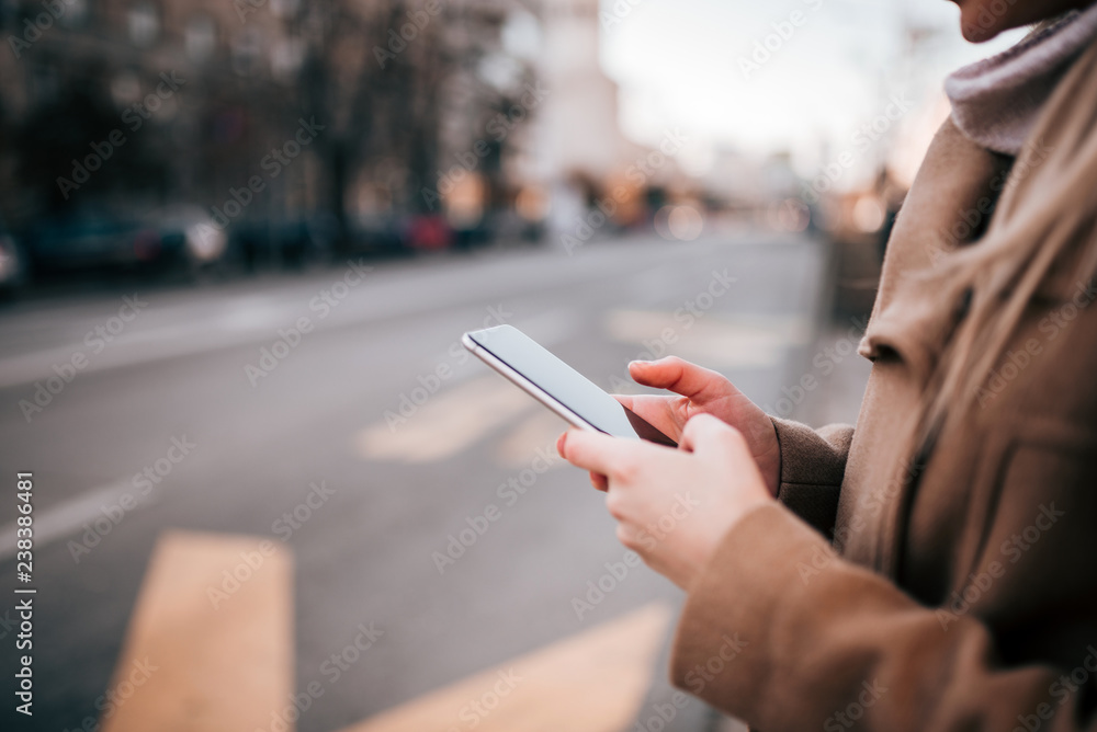 Woman using mobile phone by the city street. Woman using mobile phone by the city street.