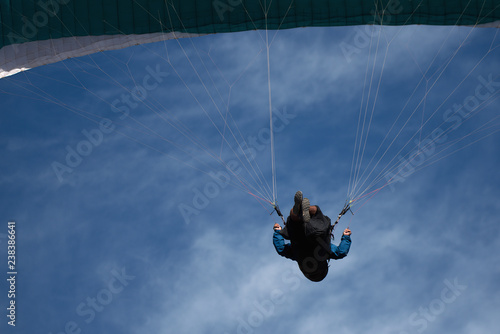 Paraglider on the background of bright blue sky, looking from below