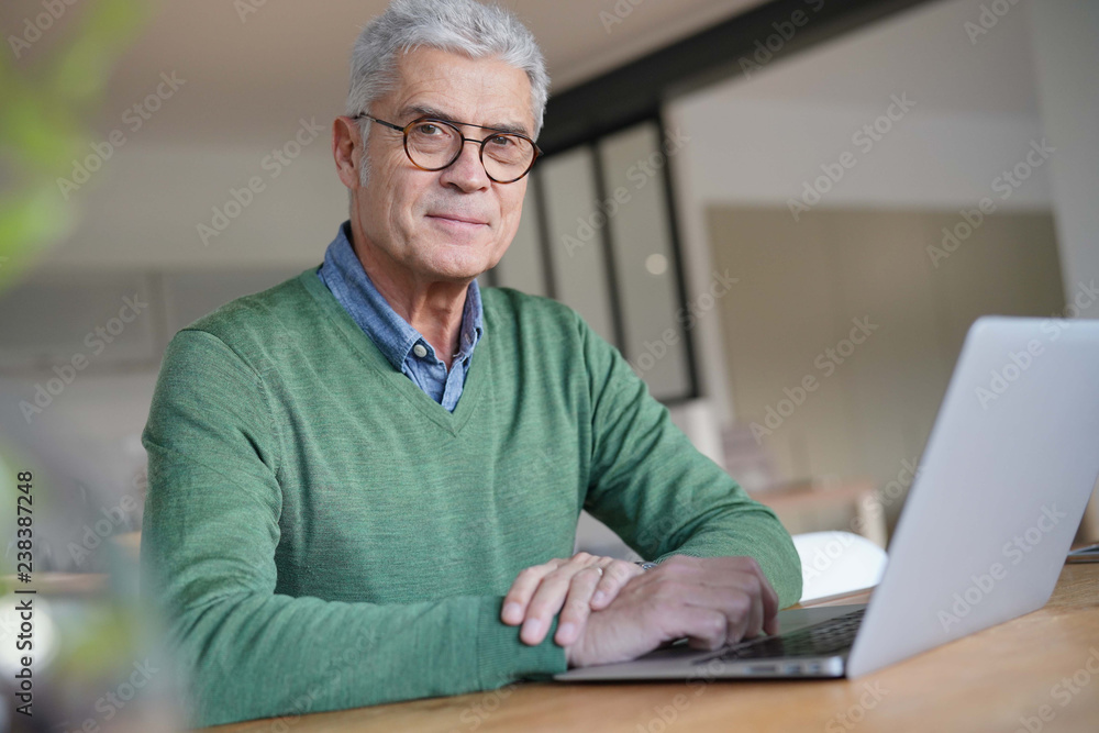 Modern senior man working on laptop at home Modern senior man working on laptop at home