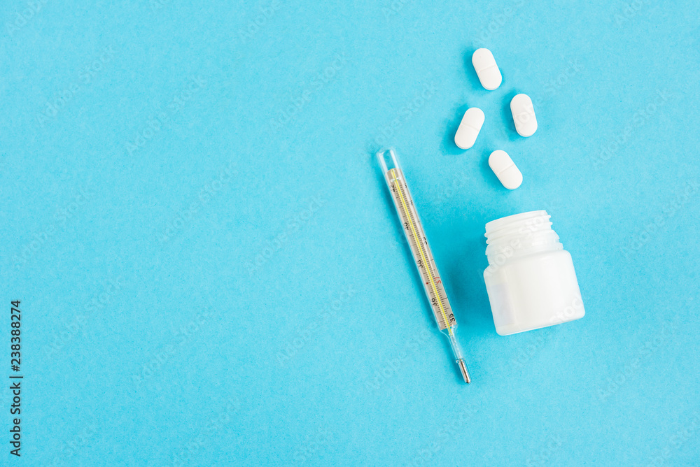 Pills and thermometer on a blue background Pills and thermometer on a blue background