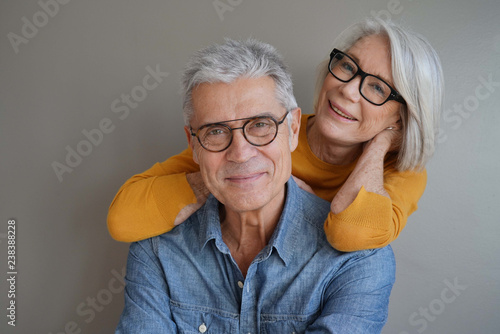  Portrait of relaxed fun senior couple wearing glasses on background photo