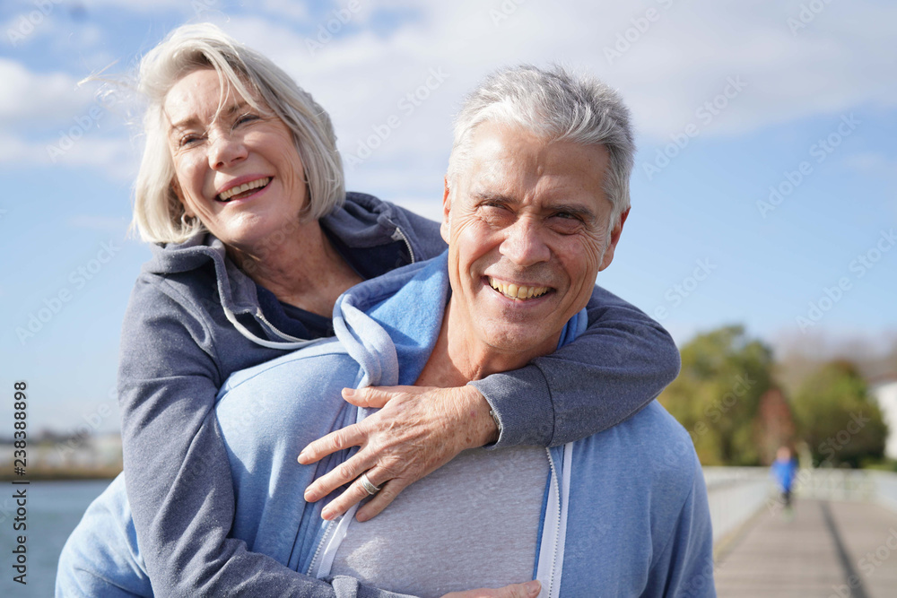 Ταπετσαρία Fun loving senior couple piggyback riding outdoors