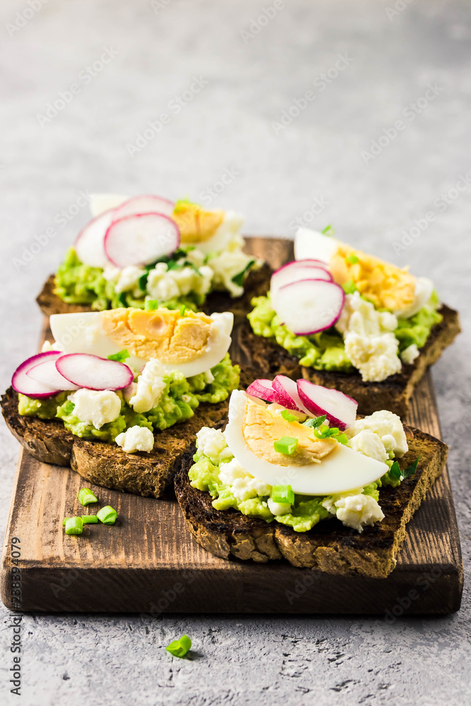 Avocado radish eggs bruschetta on cutting board. Selective fcous, space for text. Avocado radish eggs bruschetta on cutting board. Selective fcous, space for text.