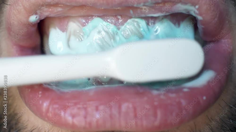 Man's open mouth and brushes his teeth in morning. Close up white man