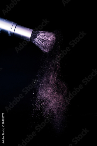 purple and pink powder color splash and brush for makeup artist or beauty blogger in black background, look like a galaxy and mystic mood.