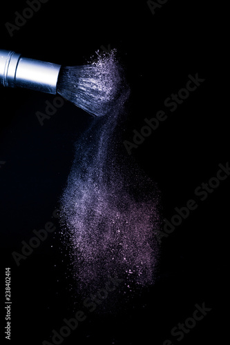 purple and pink powder color splash and brush for makeup artist or beauty blogger in black background, look like a galaxy and mystic mood.