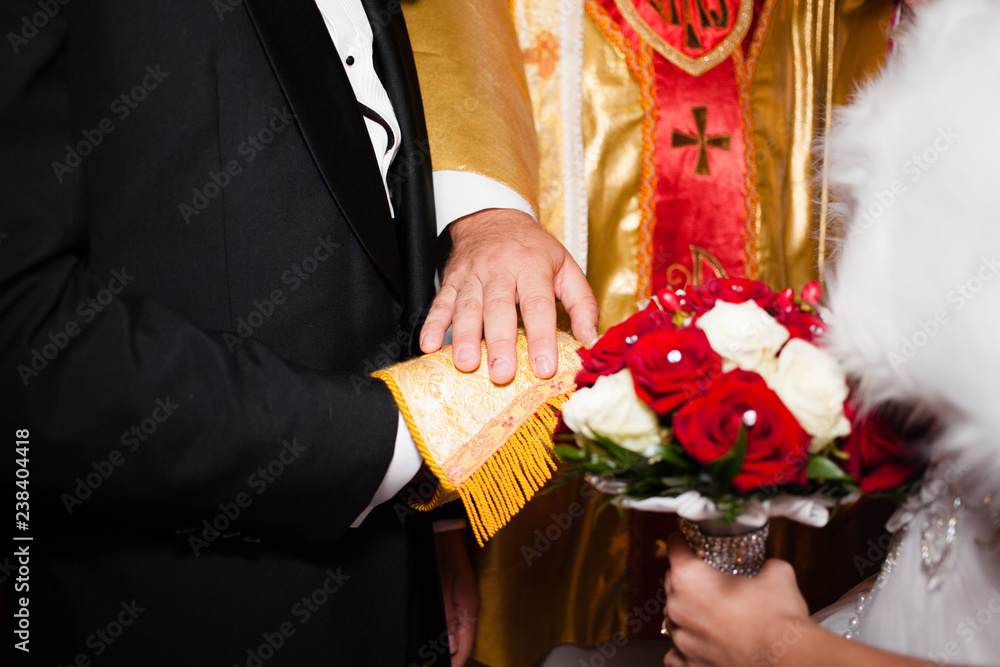 A man and a woman hold their hand under the liturgical stole of the priest.  Catholic wedding of a young couple in church Stock Photo | Adobe Stock