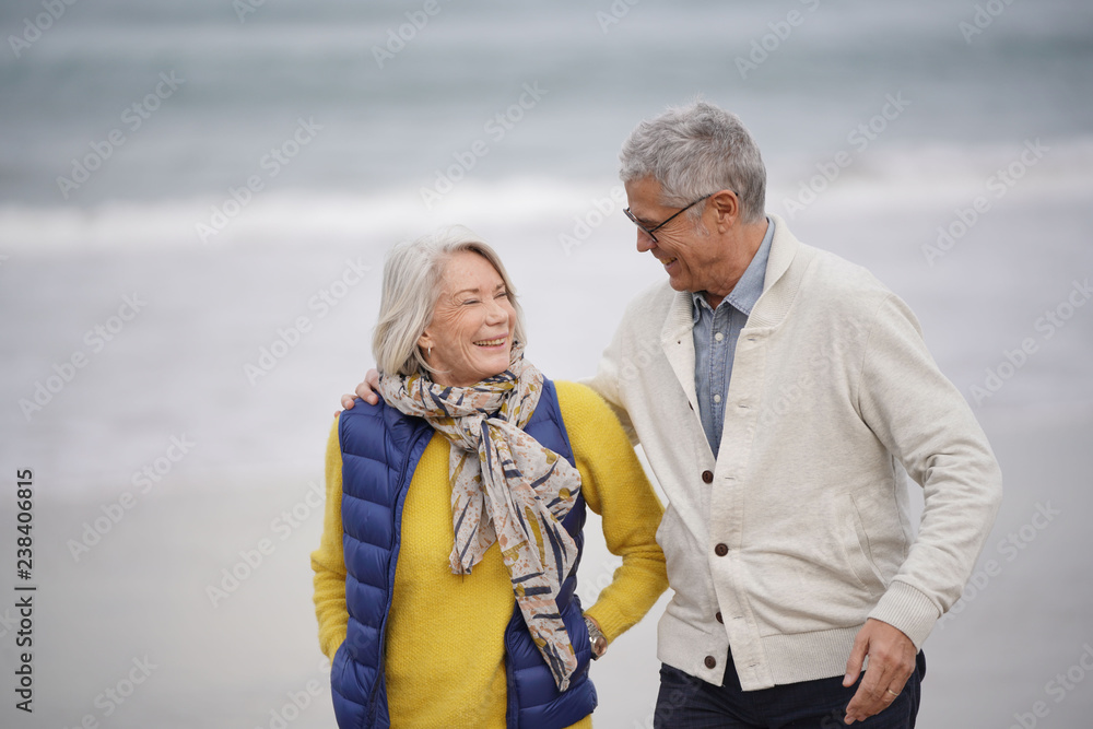  Happy senior couple walking together on the beach
