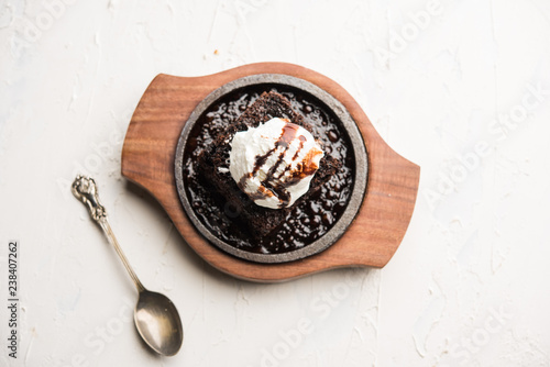sizzling chocolate brownie is a sweet dish made using scoop of ice-cream on top served with a generous pouring of melted chocolate. server hot. selective focus