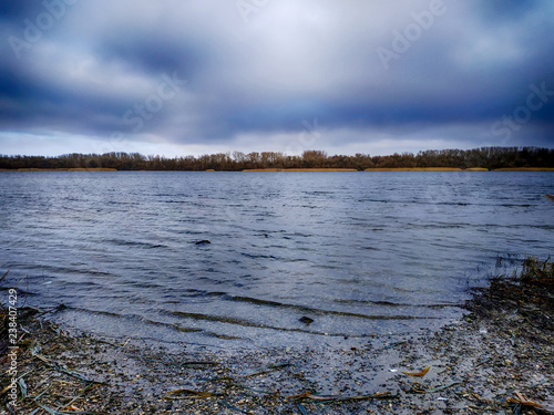Winter landscape, a certain nature. Beautiful river near colorful nature. Reeds and shore