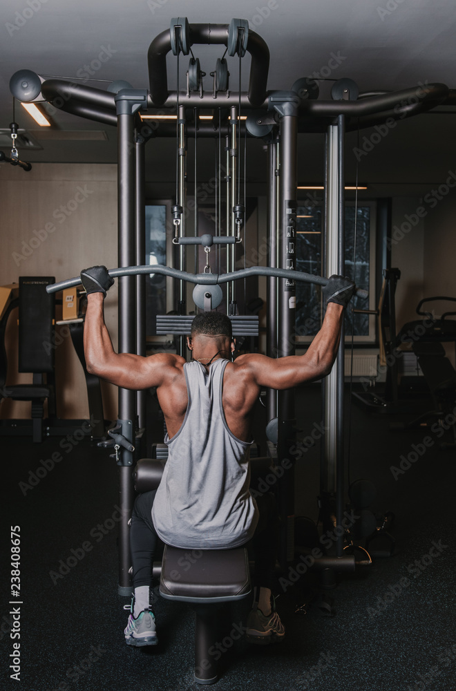 Black man exercising on machine in gym Black man exercising on machine in gym