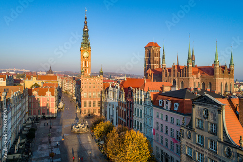 Poland. Gdansk Old City skyline with medieval Gothic Saint Mary Cathedral, city hall with clock tower, Dluga street, Artus Court and Neptune statue with fountain. Aerial view in sunrise light in fall