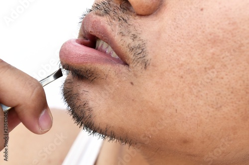 man pull mustache by tweezers on white background