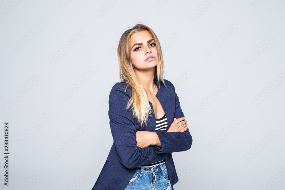 Portrait of pretty trendy woman with beaming smile with crossed arms looking at camera isolated on grey background Portrait of pretty trendy woman with beaming smile with crossed arms looking at camera isolated on grey background