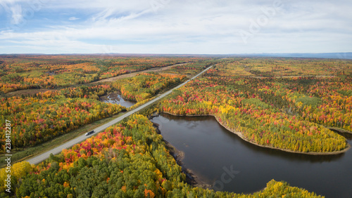 Aerial panoramic view of highway in a beautiful Canadian Landscape during fall color season. Taken near Belledune  New Brunswick  Canada.