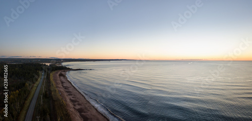 Aerial panoramic view of a Beautiful Sandy Beach on the Atlantic Ocean Coast during a vibrant sunrise. Taken near in Pabos Mills, Quebec, Canada.