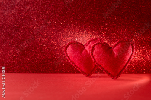 Felt hearts on red background with bokeh. Valentine s day celebration or love concept. Copy space