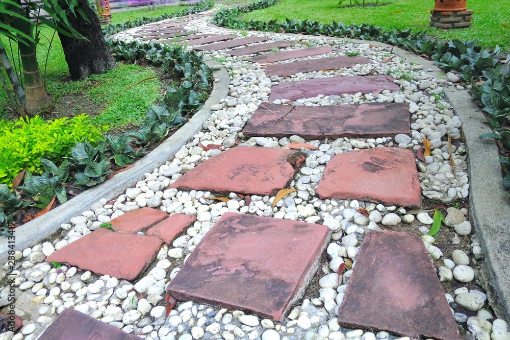 Stone pavement with green grass, walk way in the public park . Way to successful, keep walking. Background, park and business concept. Stone pavement with green grass, walk way in the public park . Way to successful, keep walking. Background, park and business concept.