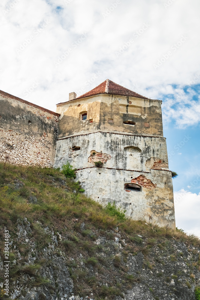 Tower of the Rasnov Fortress under the cloudy blue sky. The fortress located among the picturesque nature in the historic Rasnov city, Brasov county, Romania