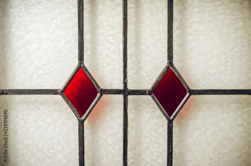 Close-up of leaded stained glass window with red diamond patterns
