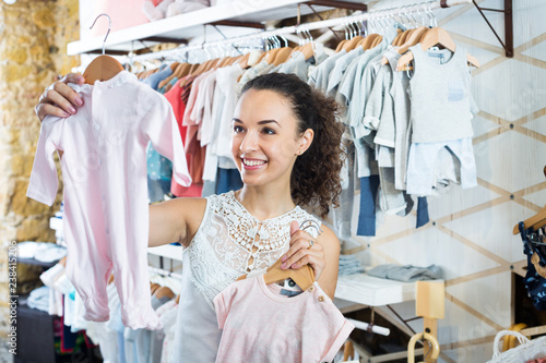 Woman choosing baby pajamas in kids boutique