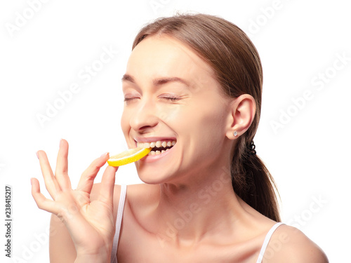 Beautiful woman with lemon beauty fashion skin freshness face, eats sour lemon on a white background. Isolation