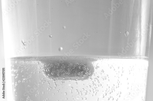 Compressa effervescente che si scioglie in un bicchiere d'acqua photo