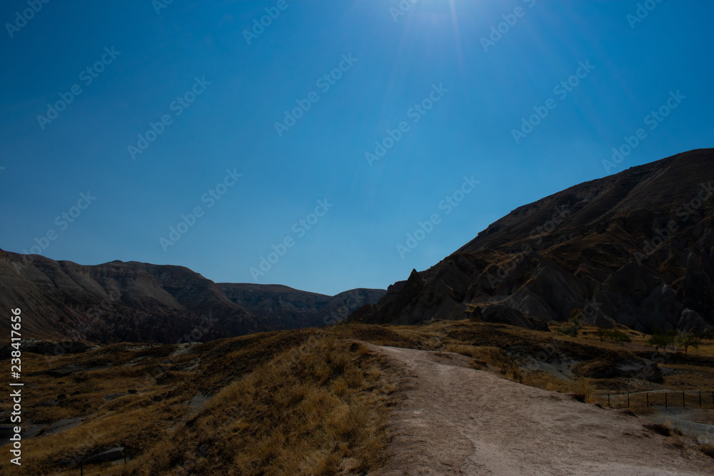 road in mountains against clear blue sky, sunny day