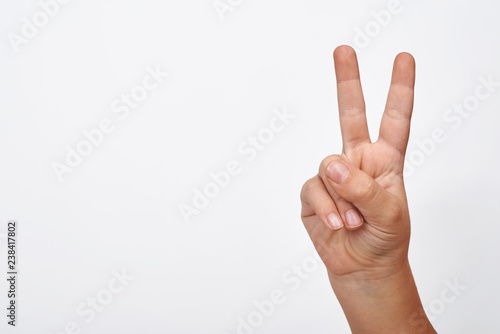 Child hand shows two finger displaying peace and win sign.