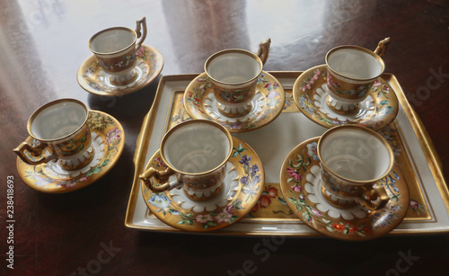 Romantic antique coffee service in Biedermaier style, hand painted in gold and enamel with colorful flowers photo