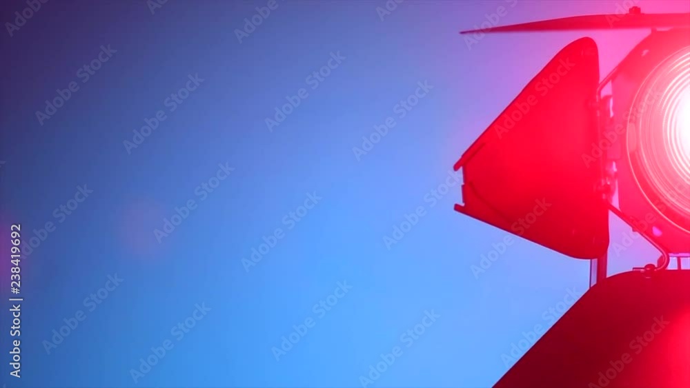 Studio floodlight. Fresnel lens light on a bright blue background. Professional colorful lighting equipment for shooting, filming and photographing. Slow motion 4K UHD video footage. 3840X2160 Studio floodlight. Fresnel lens light on a bright blue background. Professional colorful lighting equipment for shooting, filming and photographing. Slow motion 4K UHD video footage. 3840X2160