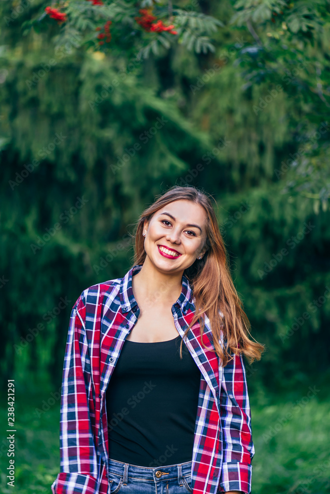 Naklejka premium Smiling woman standing in the park