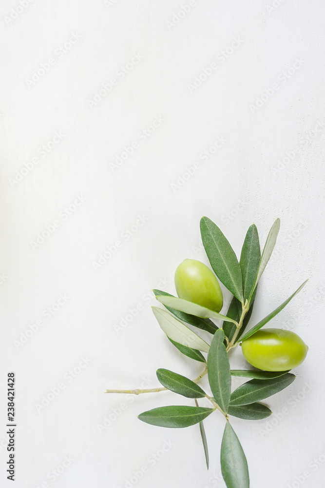 Obraz premium Olive branch on the white table with copy space