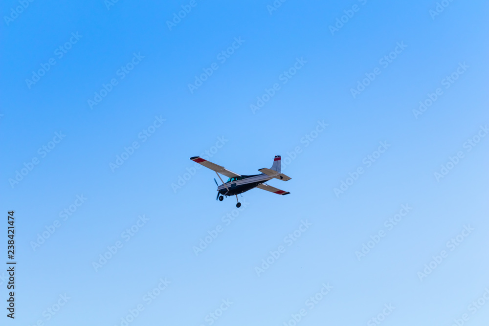 Small private aircraft flying away in blue sky Small private aircraft flying away in blue sky