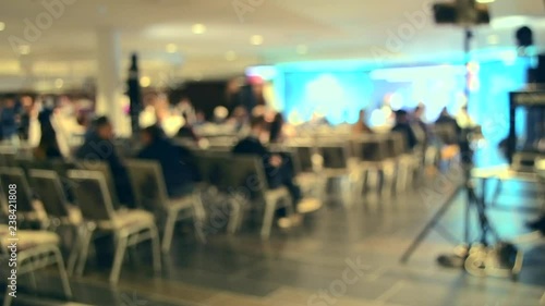 Blurred Background. Many people are sitting in the hall audience listening to presentation lecture speech at forum or conference. Neon lights photo